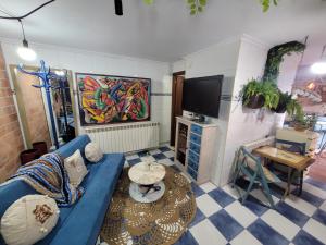 uma sala de estar com um sofá azul e uma televisão em Precioso bajo con piscina en Soto de la marina em Soto de la Marina