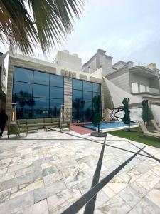 un bâtiment avec bancs devant un bâtiment dans l'établissement X Beach House, à Al Khiran