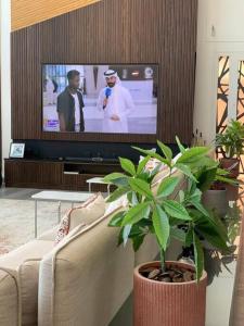 sala de estar con sofá y TV de pantalla plana en X Beach House en Al Khīrān