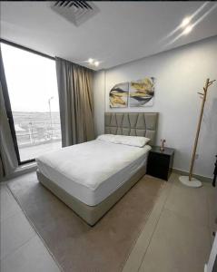 um quarto com uma cama e uma grande janela em X Beach House em Al Khiran