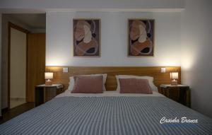 a bedroom with a large bed with two night stands at Casinha Branca in Fundão
