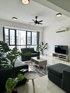 a living room with two couches and a tv at Jazz Suites Seaview with Bathtub - 2901 in Tanjong Tokong