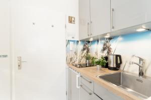 a kitchen with white cabinets and a sink at Steffi s Vogelnest in Scharbeutz
