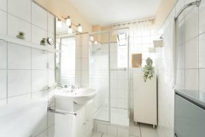 a white bathroom with a sink and a shower at Steffi s Vogelnest in Scharbeutz