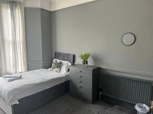 曼徹斯特的住宿－Manchester Stay Hotel - Free Parking，一间卧室配有一张带梳妆台和镜子的床