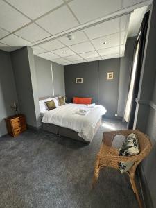 Manchester Stay Hotel - Free Parking في مانشستر: غرفة نوم فيها سرير وكرسي