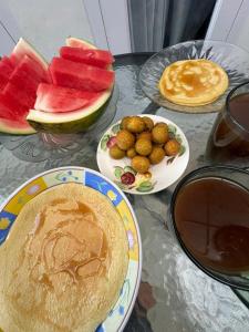 a table topped with plates of food and fruit at LOBLUS (Low Budget Luxury Stay) in Padang