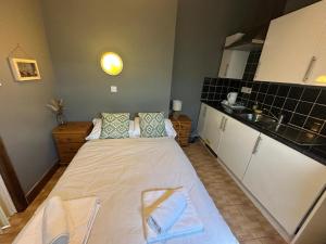 a large bed in a small room with a kitchen at Manchester Stay Hotel - Free Parking in Manchester