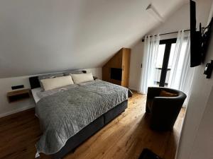 a bedroom with a bed and a chair at Ferienwohnungen Heimatliebe in Ernst
