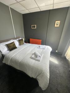 um quarto com uma cama grande e lençóis brancos em Manchester Stay Hotel - Free Parking em Manchester