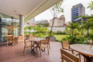 un patio extérieur avec des tables, des chaises et des bâtiments dans l'établissement FL Residence, à São Paulo