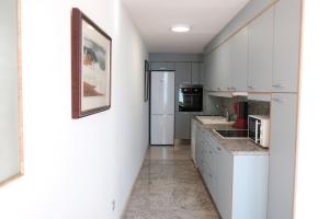 a kitchen with white cabinets and a refrigerator at Exclusive Beachfront Haven in Costa Brava in Lloret de Mar