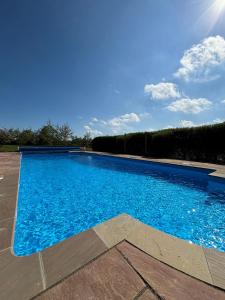 een groot zwembad met blauw water bij Ashfield Place Farm by Group Retreats in Stowmarket