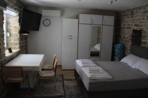 a bedroom with a bed and a table and a desk at Kod Mladena in Buković