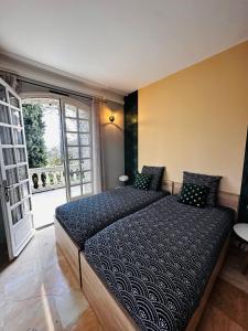 um quarto com uma cama grande e uma janela grande em "Les Hauts du Marquet" - Meublé de tourisme 5 Etoiles - Gîte de groupe 15 Personnes en Cévennes - Piscine à débordement - Balnéo - Sauna - Nature em Saint Jean du Pin