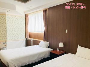 a hotel room with two beds and a window at Hotel Precia Naha Tsujimachi - Vacation STAY 17058v in Naha +12 photos