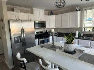 een keuken met een tafel en een roestvrijstalen koelkast bij Lake Life in Huddleston