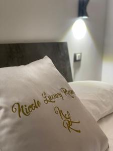 a pillow on a bed with the words nadiyingyayarosis written on at NICOLE LUXURY ROOMS in Fondi