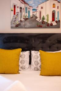 uma cama com duas almofadas amarelas num quarto em The Millennial Prime Umhlanga em Durban