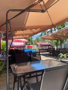 a patio with tables and umbrellas at Hotel Nika in Ureki in Ureki