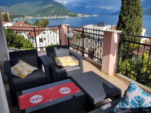a balcony with chairs and a view of the water at Monteview Loft Apartment in Herceg-Novi
