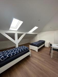 2 Betten in einem Zimmer mit Dachfenster in der Unterkunft Ar Living Frankfurt Königsteinerstr in Frankfurt am Main