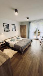 sypialnia z dużym łóżkiem i drewnianą podłogą w obiekcie Olimpijska pokoje w Szczyrku