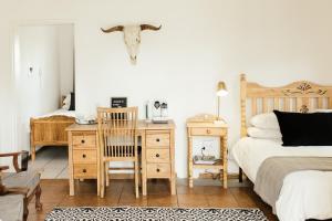 a bedroom with a bed and a desk with a chair at Kanaal kooi in Upington