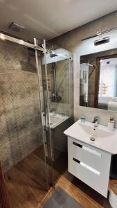 a bathroom with a sink and a shower at Olimpijska pokoje in Szczyrk