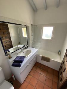 een badkamer met een wastafel, een bad en een spiegel bij Calicho in Urrugne