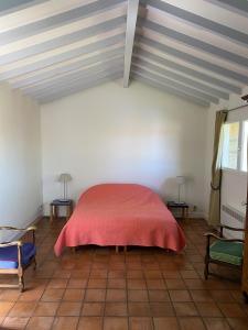 een slaapkamer met een rood bed en 2 stoelen bij Calicho in Urrugne