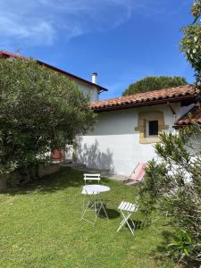 a table and two chairs in the yard of a house at Calicho in Urrugne +6 photos