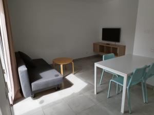 sala de estar con mesa y silla en Alisios Playa, en Corralejo