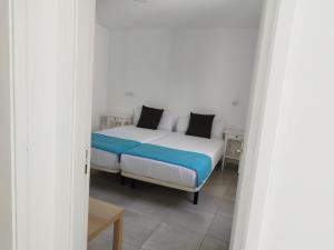 a bedroom with a bed in a white room at Alisios Playa in Corralejo