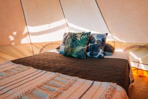 - un lit dans une tente avec 2 oreillers dans l'établissement Glamping Guayaha, à Lanquín
