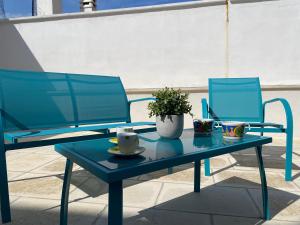 due sedie blu e un tavolo con una pianta sopra di Casa Donna Gina - Puglia Mia Apartments a Monopoli