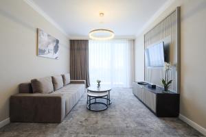 a living room with a couch and a tv at Panoramic Mamaia Hotel in Mamaia
