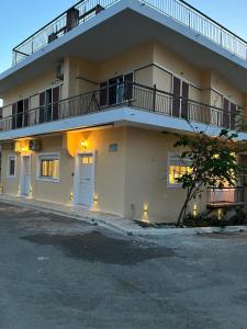 a large white building with a porch and a balcony at Olive Gem Apartment in Spilia in Spiliá