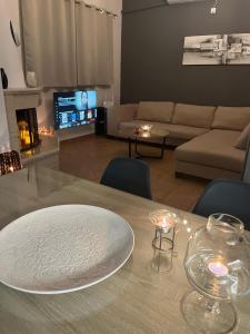 a table with a white plate on top of it in a living room at Olive Gem Apartment in Spilia in Spiliá