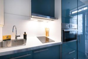 een keuken met blauwe kasten en een wastafel bij Chaleureux Studio 2 pers in Lyon