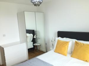 een slaapkamer met een spiegel en een bed met gele kussens bij Media City Salford Quays in Manchester