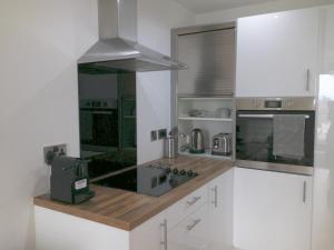 uma cozinha com armários brancos e um forno com placa de fogão em Media City Salford Quays em Manchester