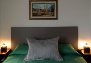 a bedroom with a green bed with a picture on the wall at Punto Golondrina in Alta Gracia