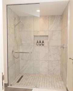 a bathroom with a shower with a glass door at Capital M - Bednbeyond, Westlands Nairobi, Kenya-Call 25472I95O319 in Nairobi