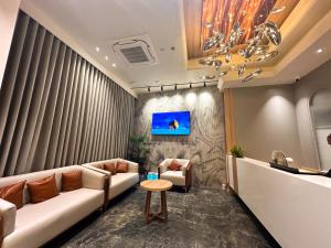 a waiting room with couches and a tv at Hotel Park Royal in Dwarka