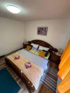 a bedroom with a large wooden bed with pillows at Studio Apartman Josip in Gospić