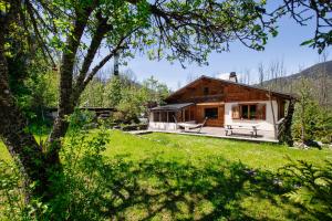 uma casa no meio de um campo verde em Chalet 4BR Wood Stove , Home Cinema , Parental Suite em Les Houches