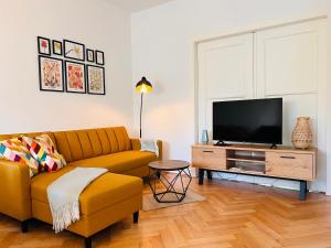 a living room with a couch and a flat screen tv at cardia homes Ferienwohnung Erfurt-Hopfenberg - Terrasse - Wlan - Vollausstattung in Erfurt