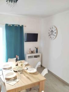 a dining room with a table and a clock on the wall at Apartment Lopar 13 in Lopar