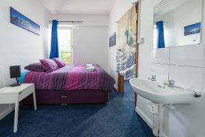 Schlafzimmer mit einem Bett, einem Waschbecken und einem Waschbecken in der Unterkunft Pax Lodge in London